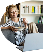 一个女人一边吃早餐一边放松，一边用笔记本电脑和她的经纪人聊天.