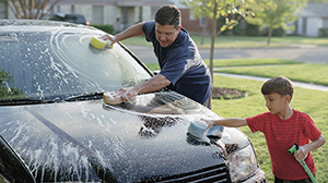 Father and son washing a car