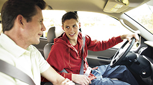 Teenage boy learning how to drive a car 