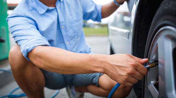 Man putting air in a car tire