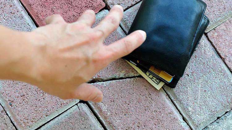 Hand reaching for wallet on ground