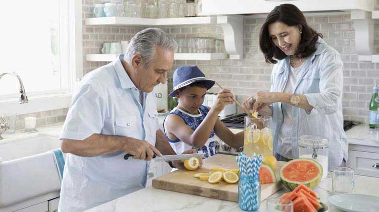 Family cutting up fruit in the kitchen