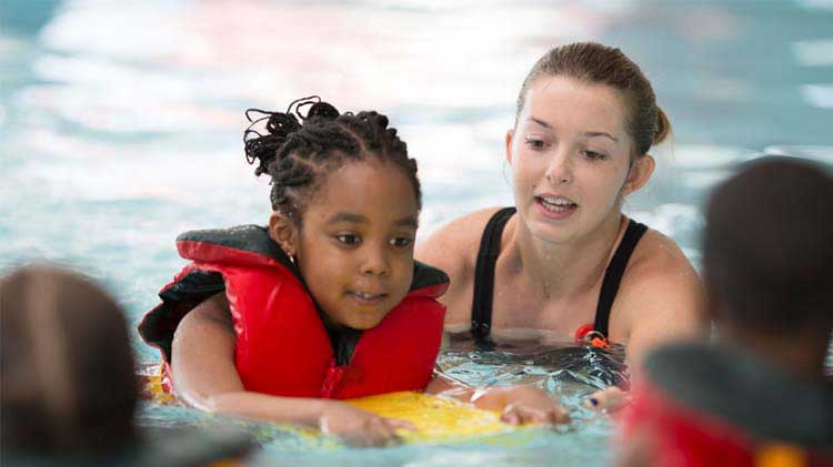 A young girl taking swimming lessons