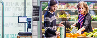 Man and Women shopping for oranges in grocery store