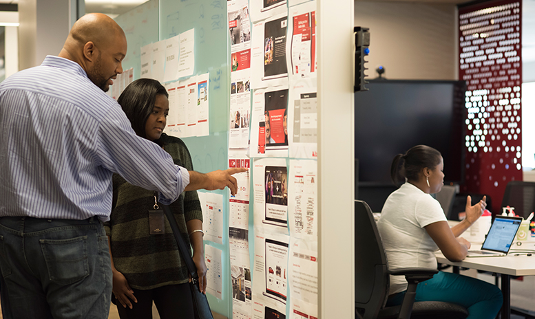 Man and women looking at schedule hanging on wall