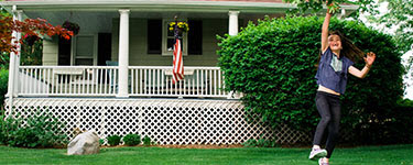 Child running in idyllic manicured front suburban lawn