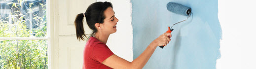 Women painting a wall blue