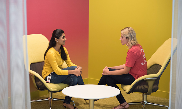 Two women talking in a very colorful room