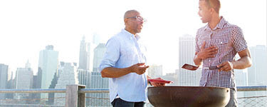 Father and son grilling hamburgers on pier