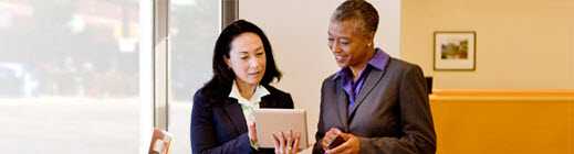 Two business women discussing a folder they are both looking at