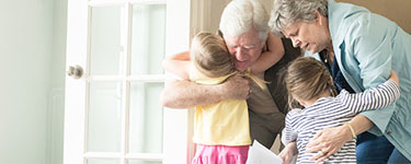Life Events - Empty Nester - Grandparents hugging grandchildren