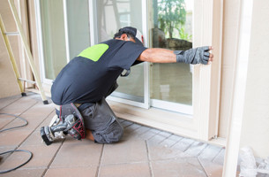 Man installing a window into a wall