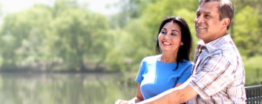 Man and woman standing on a bridge by a river