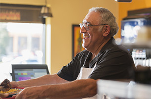 Man behind counter smiling at customer