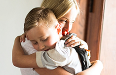 Mother hugging young son