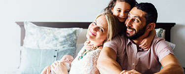 Happy family sitting on bed