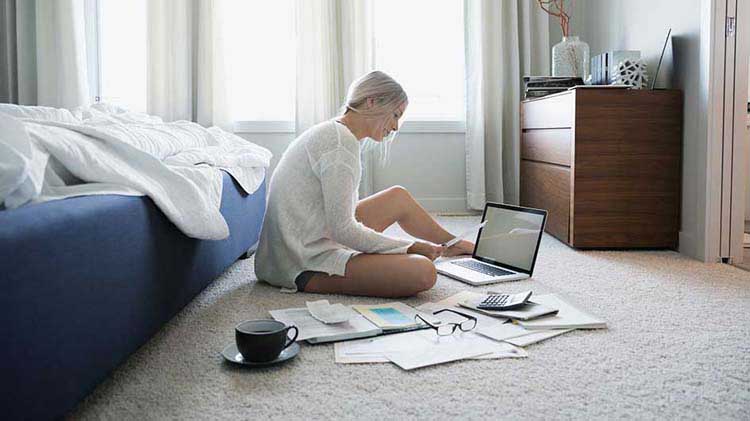 Woman at laptop with papers