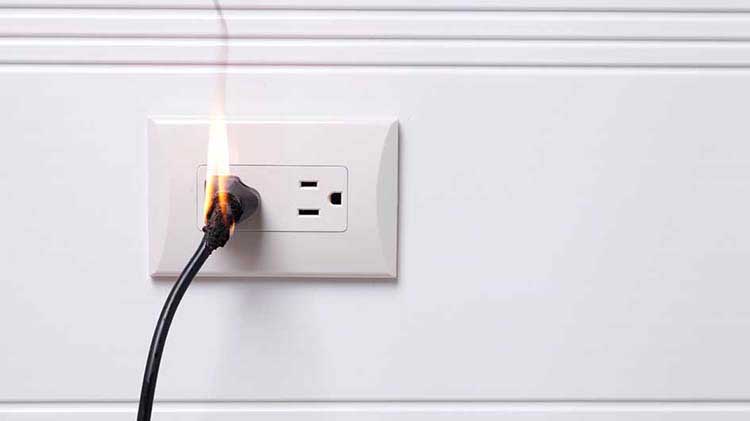 Electric cord in an outlet lighting on fire