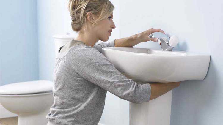 Woman fixing a leaky sink