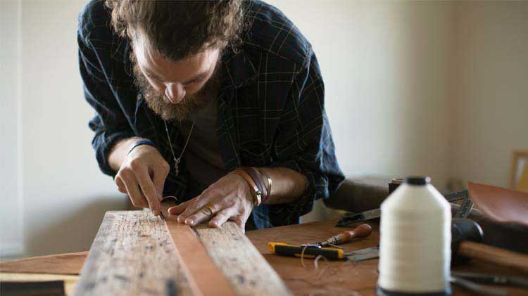 Man crafting a belt on a table