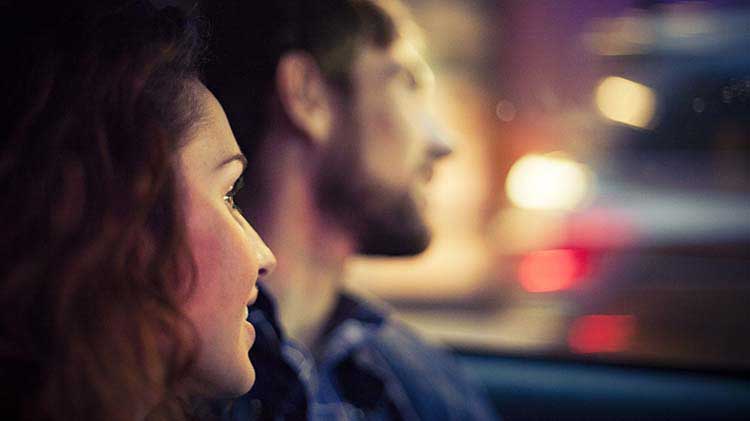 A couple is seen close up while driving a car after leaving a house party