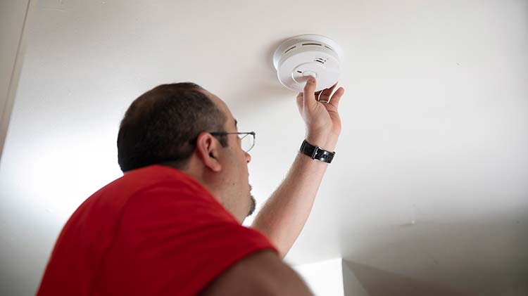 Un hombre prueba un detector de gas natural en una vivienda.