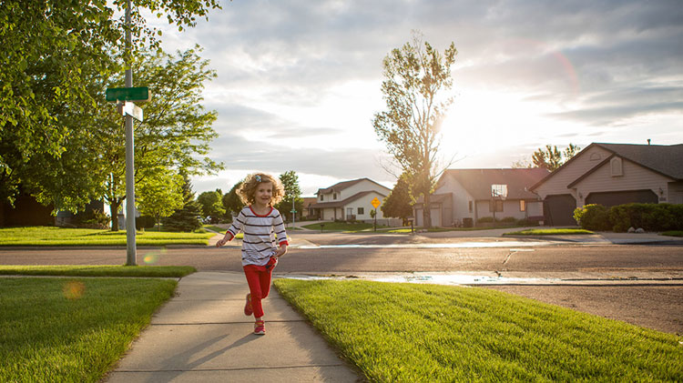 Child running in a neighborhood made safe by neighborhood social media network