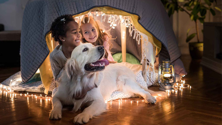 Happy little girls relaxing with golden retriever