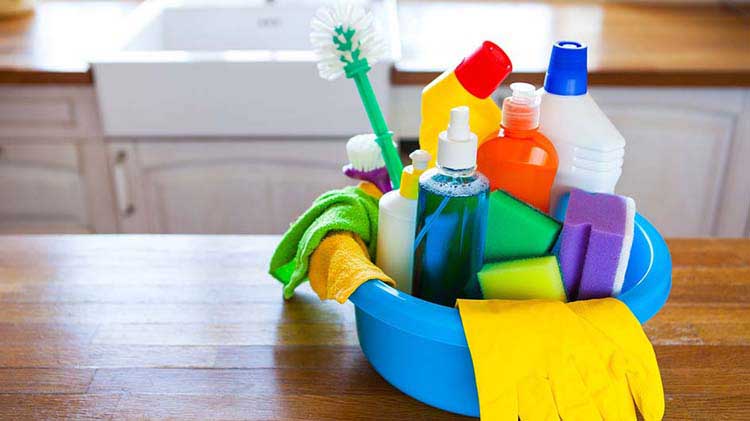 Bucket of cleaning supplies on a table