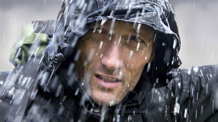 Un hombre con poncho de lluvia durante una tormenta