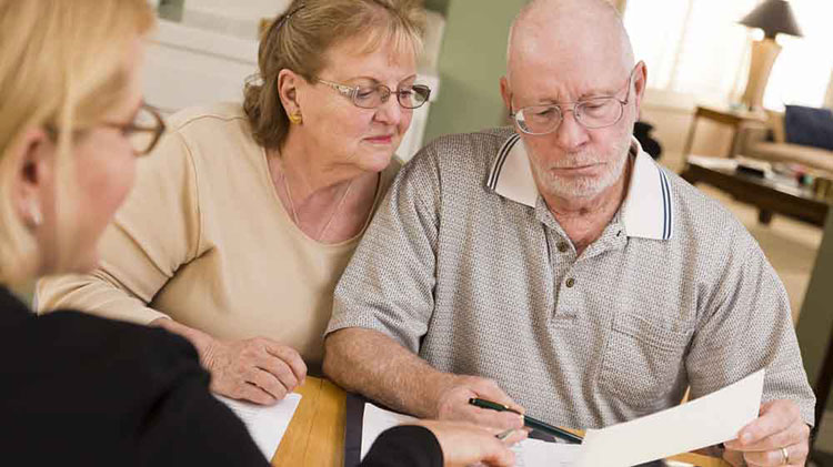 Pareja de adultos mayores revisando un testamento con un abogado
