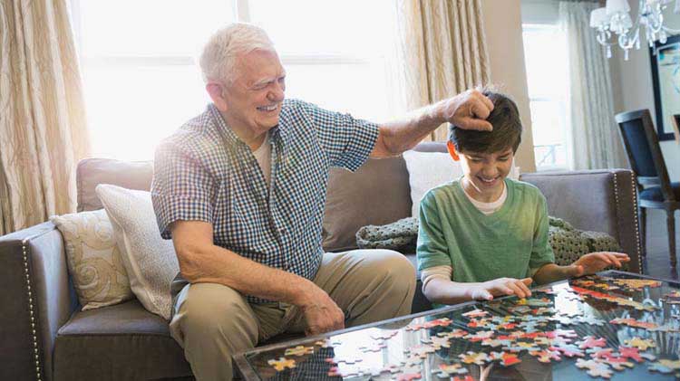 Grandfather and child putting a puzzle together.